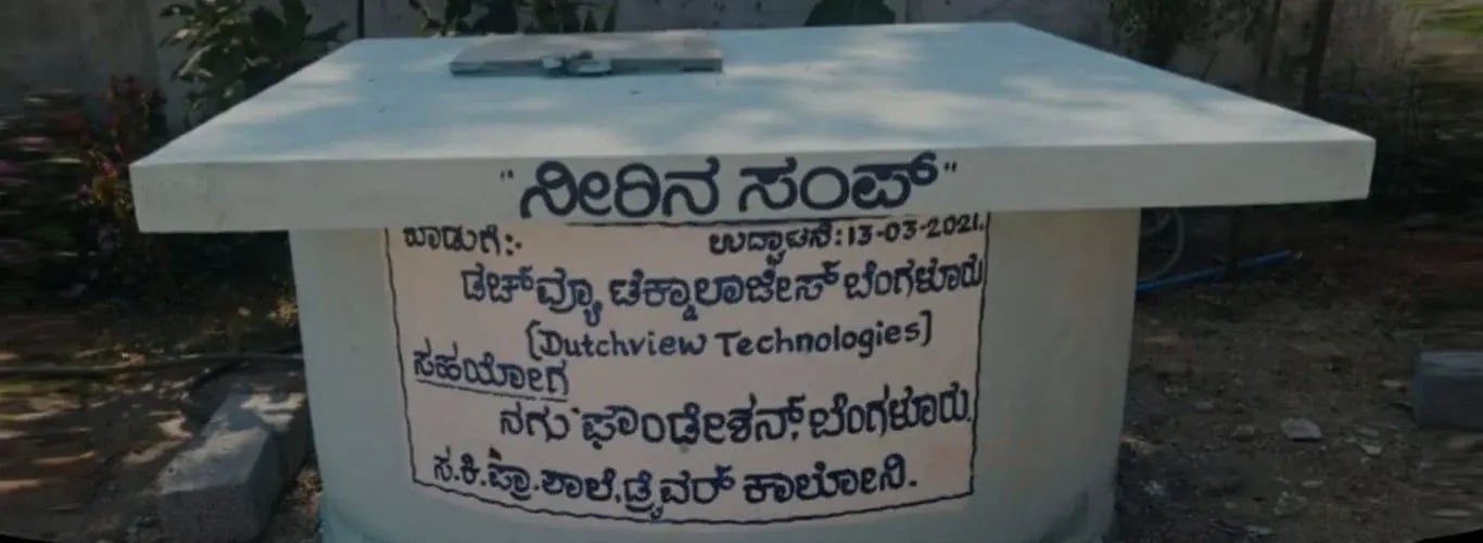 Wassertank an einer staatlichen Grundschule in Karnataka mit einer Inschrift auf Kannada, die Dutchview Technologies und die NAGU Foundation nennt